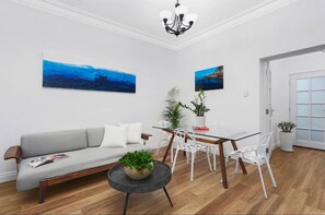 Relax in this stylish living room with a sofa, coffee table, and dining area.