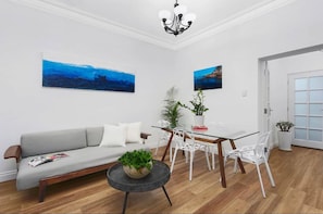 Relax in this stylish living room with a sofa, coffee table, and dining area.