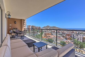 A balcony with outdoor furniture, a grill, and a view of buildings and mountains. - Golf Resort Condo w/ Ocean Views at Cabo Quivira (Cabo San Lucas)