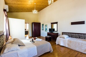 Habitación de hotel con dos camas, techo de madera, escritorio, espejo y obras de arte en las paredes.