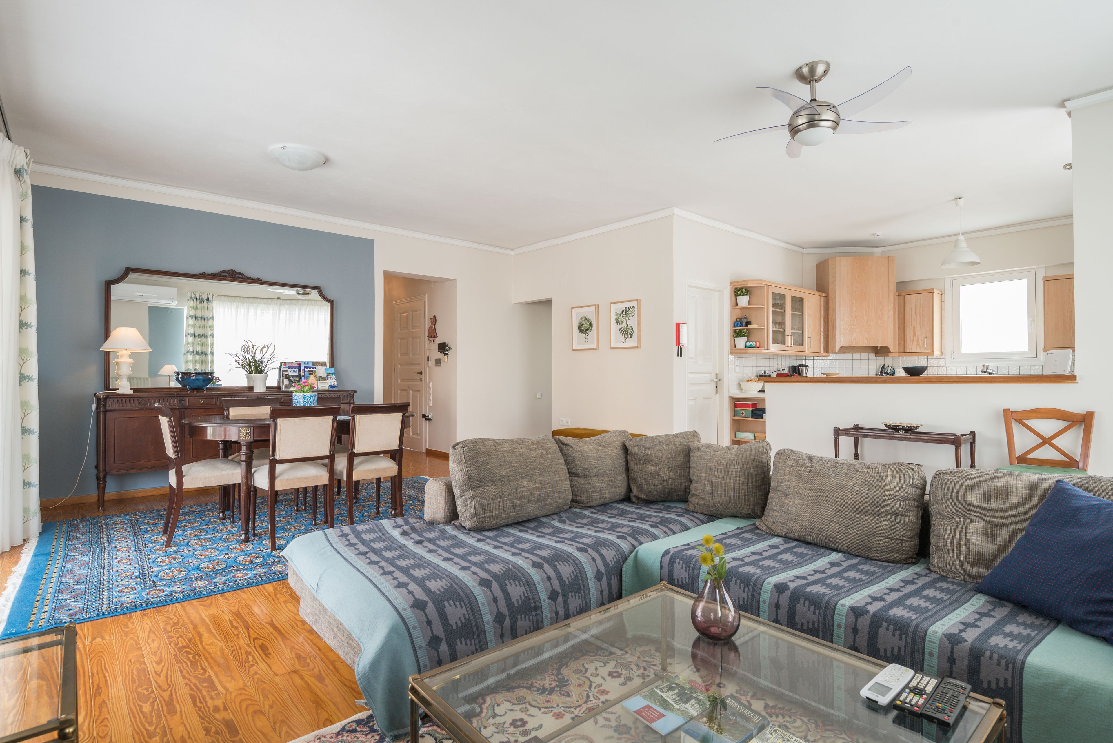 A living room with a sofa, coffee table, and a dining area with chairs and a table.