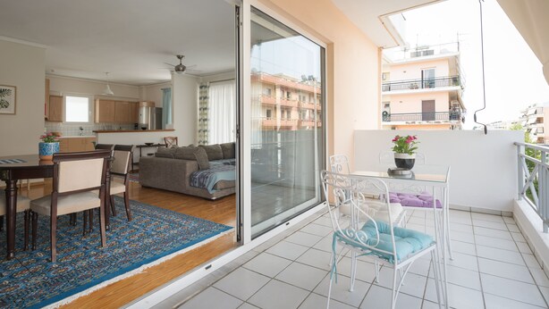 Een modern appartement met een balkon, een eethoek en een keuken.