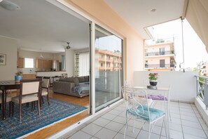 A modern apartment with a balcony, a dining area, and a kitchen. - Comfi City Apartment FIL27 (Kalamata)