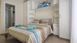 Un dormitorio con cama, armario y un cuadro en la pared.