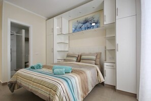 Una camera da letto con un letto, un armadio e un quadro appeso al muro.