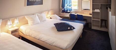 Une chambre d’hôtel avec deux lits, un bureau, une chaise, une armoire et un miroir dans la salle de bain.