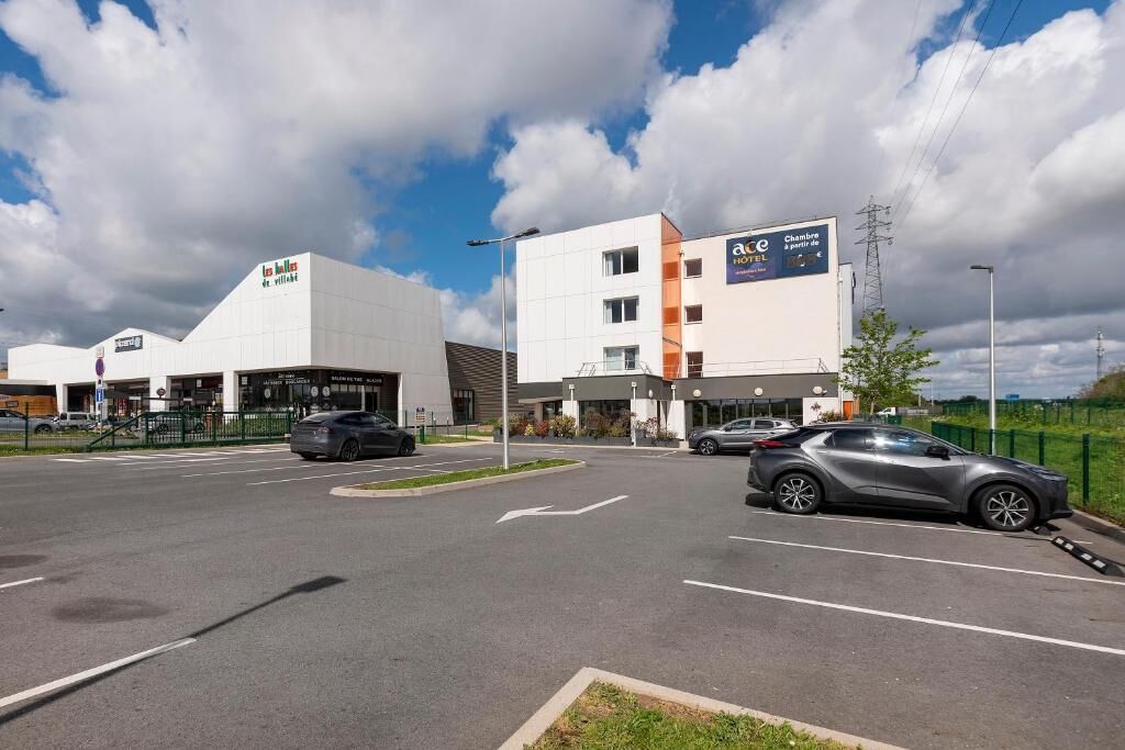 Ein Hotel mit modernem Design, einem Parkplatz und blauem Himmel.