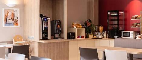 Un café moderno con mobiliario de madera, una máquina de café y un microondas.