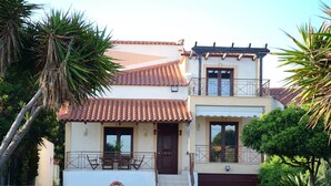 A two-story house with a tiled roof, a balcony, and a garage. - Villa Bella Loukisia (Chalcis)