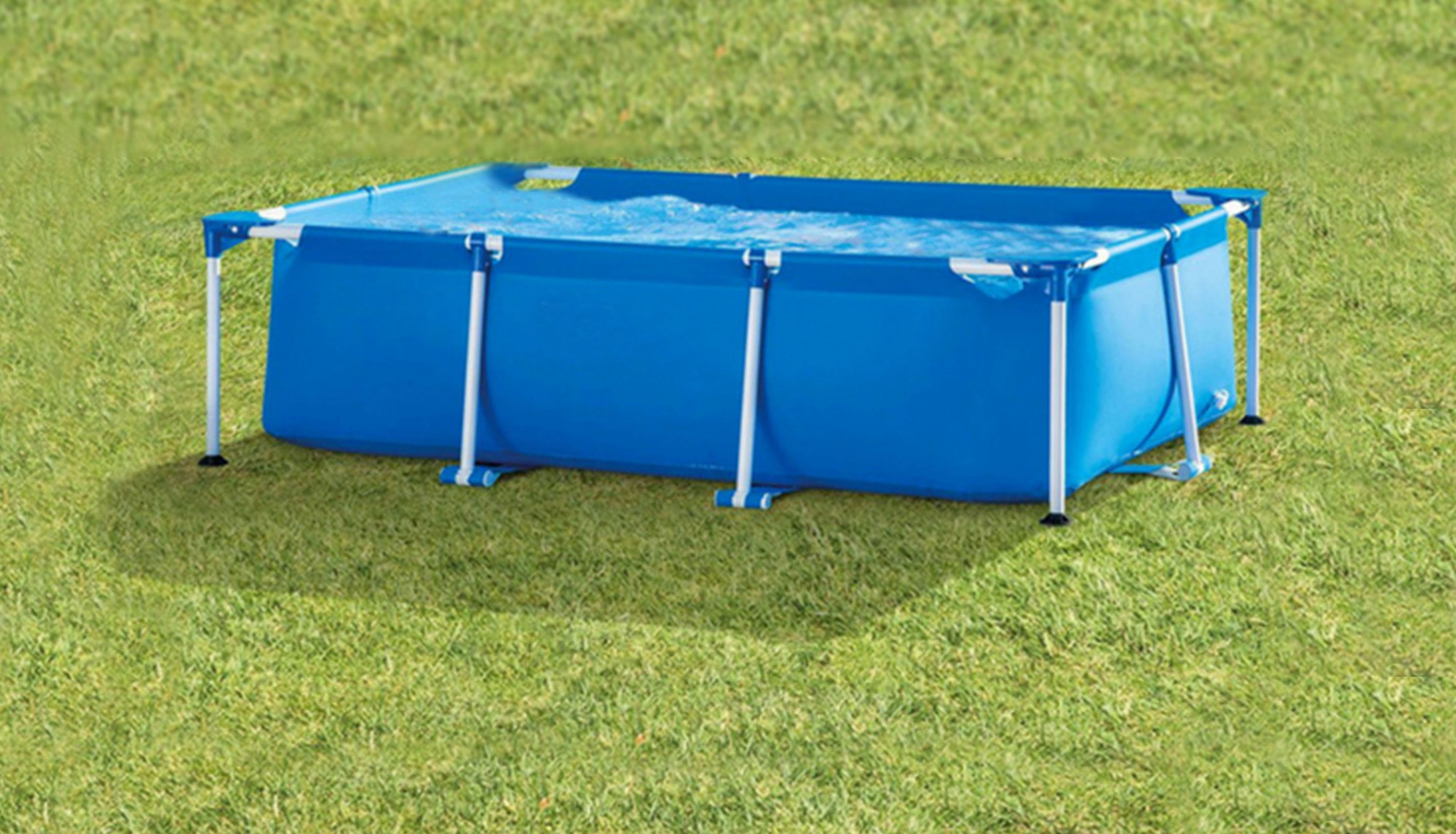A blue rectangular pool with a ladder on one side, surrounded by grass.