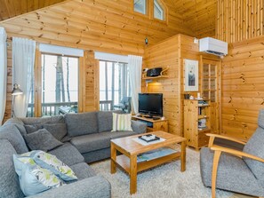 A cozy cabin interior with a sofa, a television, and a small table. - Sammonranta by Interhome (Lieksa)