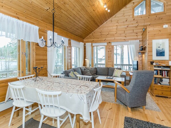 A cozy cabin interior with a dining area, sofa, and a bookshelf. - Sammonranta by Interhome (Lieksa)