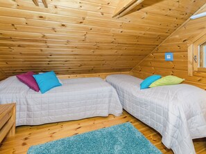 A small, cozy room with two beds, a blue rug, and wooden walls. - Sammonranta by Interhome (Lieksa)