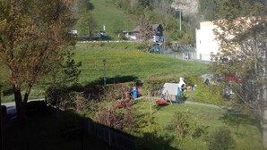 Un barrio residencial con casas en una ladera, un parque infantil y cielo despejado.