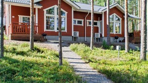 A cabin with a gravel path leading to the entrance, surrounded by trees.