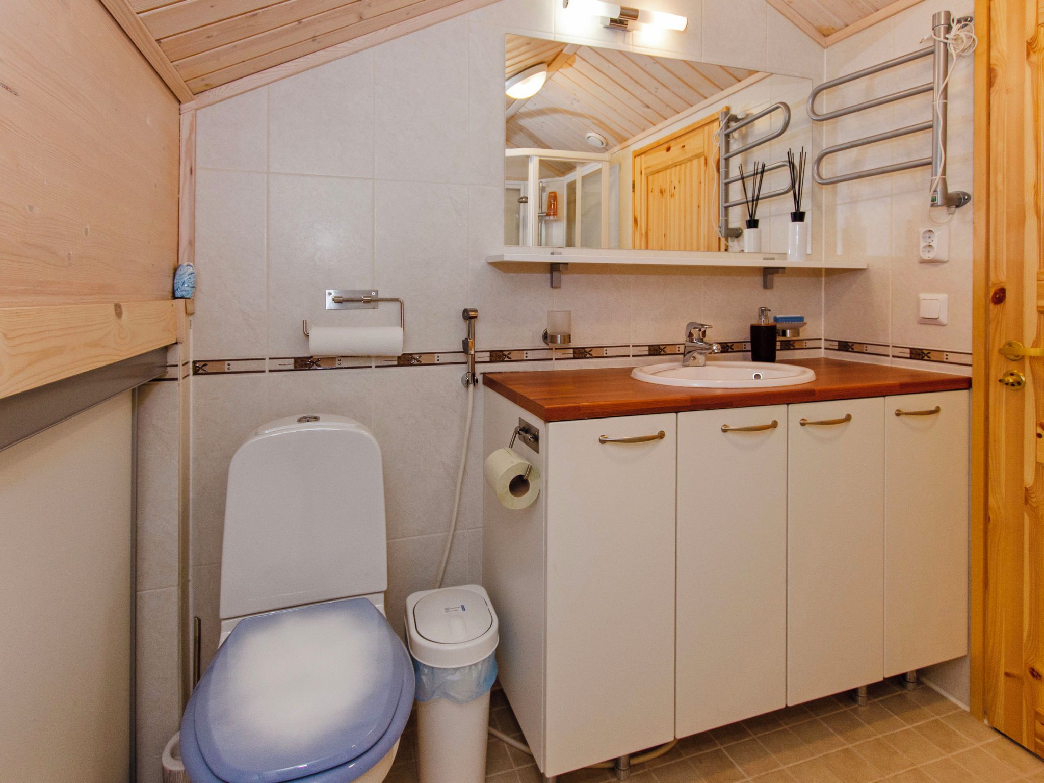 A compact bathroom with a toilet, sink, and cabinets.