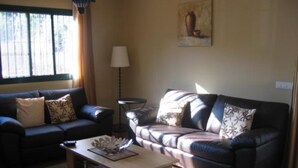 A living room with two sofas, a coffee table, a lamp, and a painting on the wall. - Fabulous family friendly 4 bed villa with private pool (Alcaucín)