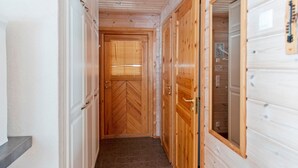 A hallway with wooden doors and a tiled floor.