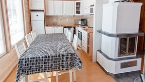 A compact kitchen with white cabinets, a stove, a microwave, and a refrigerator.