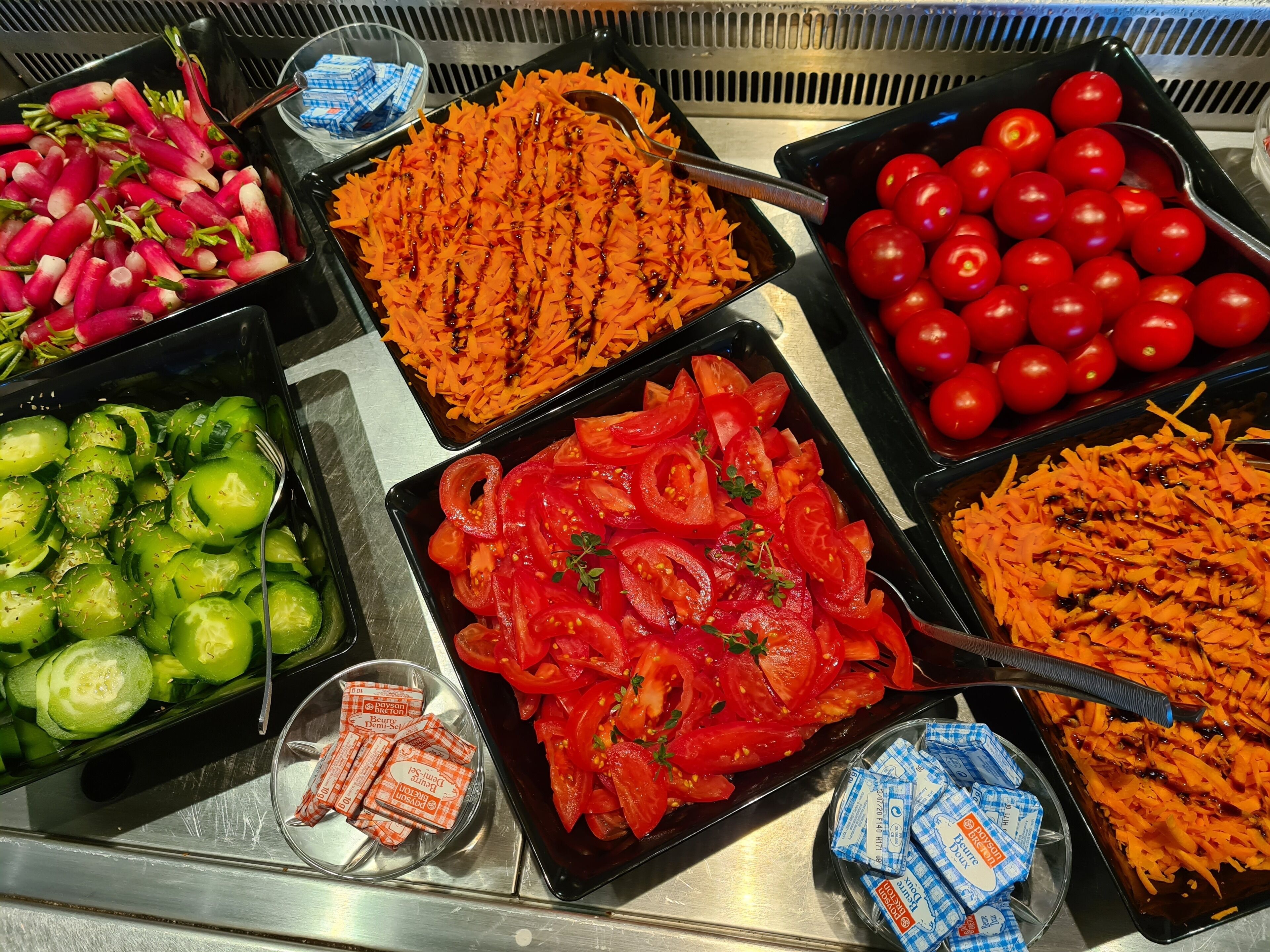 A buffet with various food items including sliced vegetables and condiments.