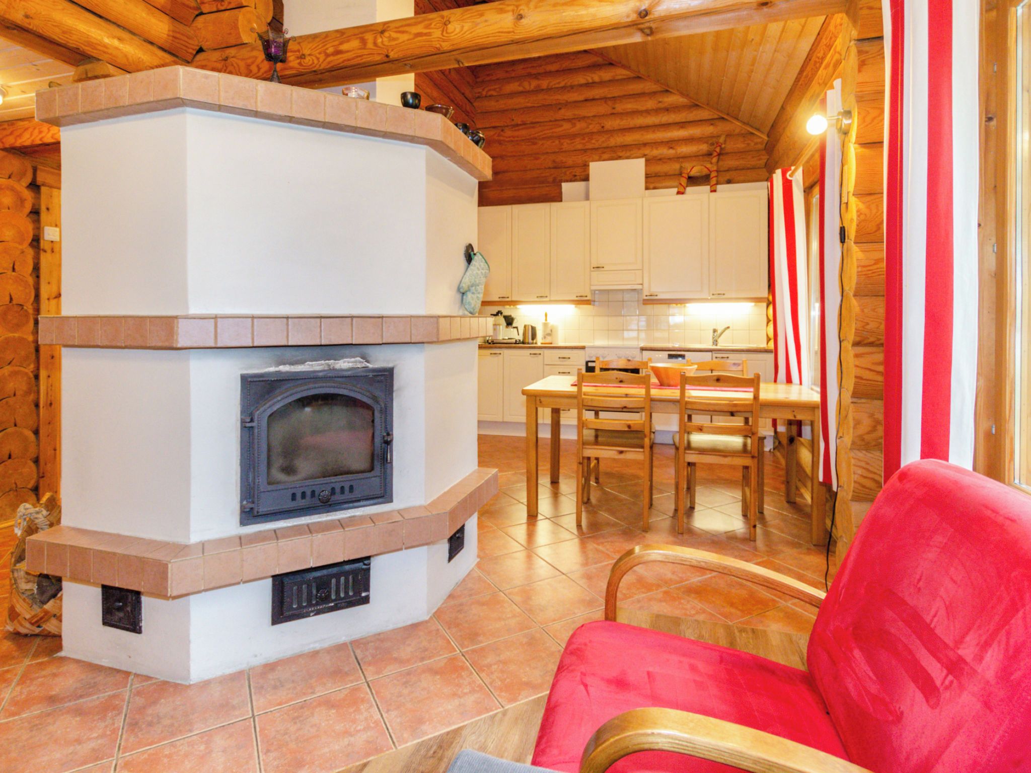 A cozy interior with a fireplace, wooden furniture, and a kitchen area.