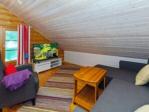 Una sala de estar estilo loft acogedora, con televisor, sofá y mesa de centro.