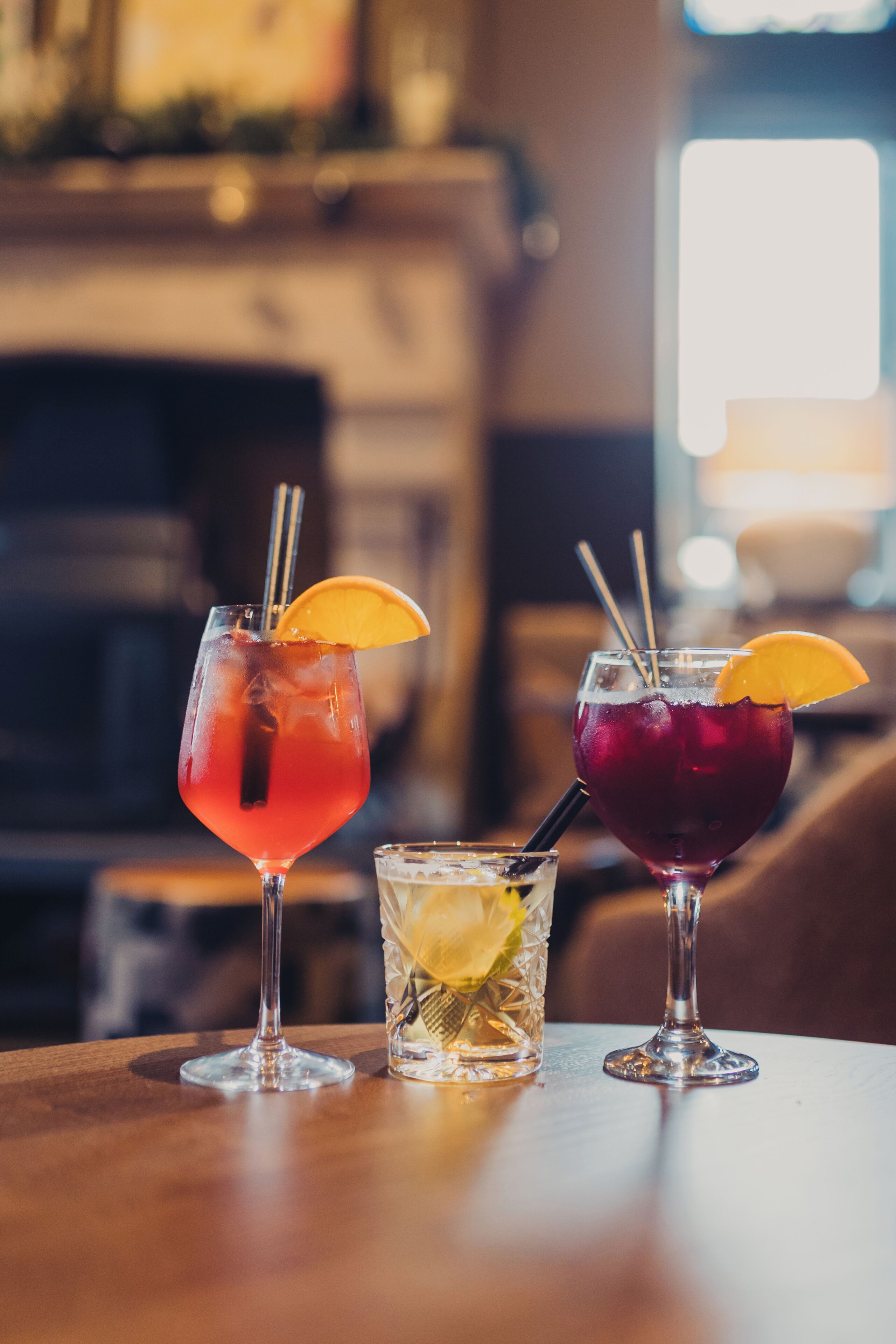 Two glasses of beverages on a table with a blurred background.
