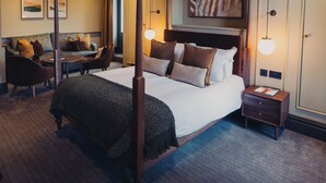 A hotel room with a large bed, a desk, a sofa, and a wall-mounted artwork. - The Wheatley Arms (Ilkley)