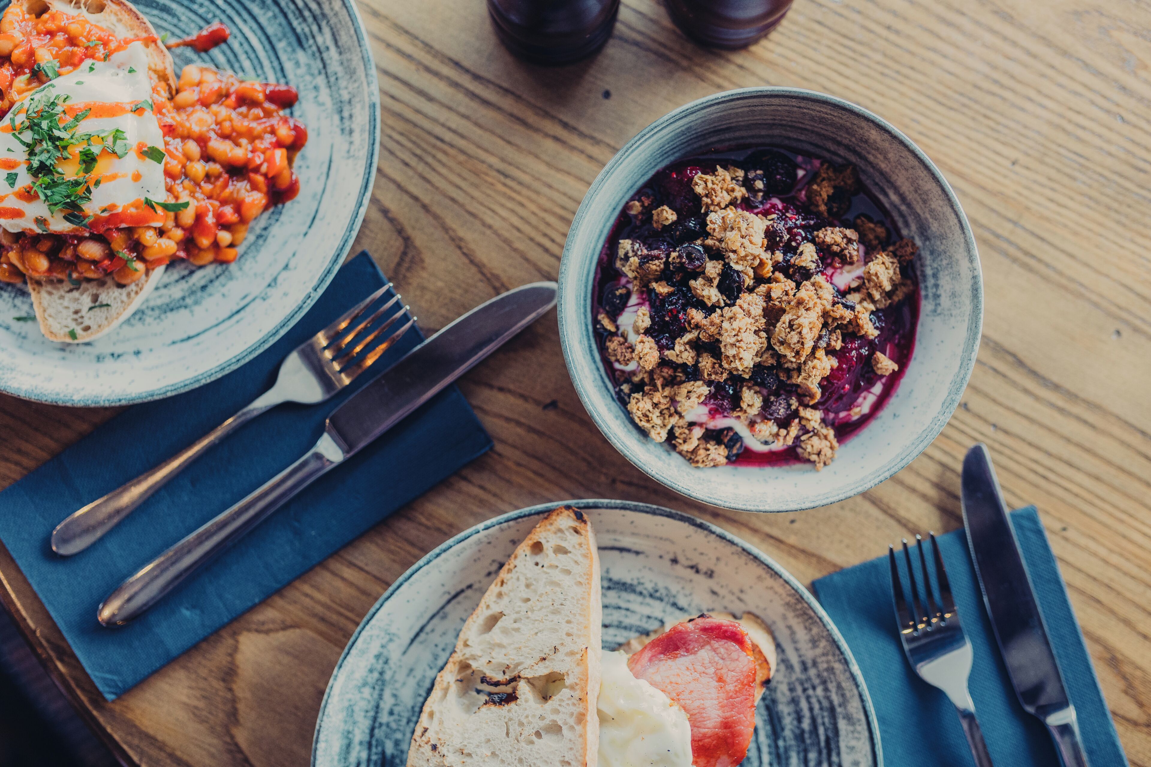 Ein Tisch mit Tellern voller Essen, Besteck und einer Serviette.