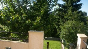 A patio area with a tiled floor, a low wall, and a metal railing. - Charming cottage near the Sioule River with private garden (Saint-Germain-de-Salles)