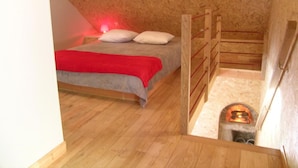 A bedroom with a wooden bunk bed, a red blanket, and a small fireplace. - Cozy house with pool and sauna in nature (Vernusse)