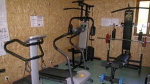 A gym with treadmills, a stationary bike, and weightlifting equipment. - Cozy house with pool and sauna in nature (Vernusse)