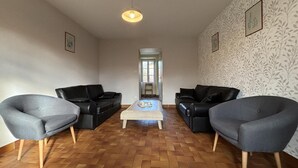 A living room with two black leather sofas, a wooden coffee table, and a herringbone-patterned wooden floor. - Spacious lodging in La Guillermie, pets allowed, garden (La Guillermie)