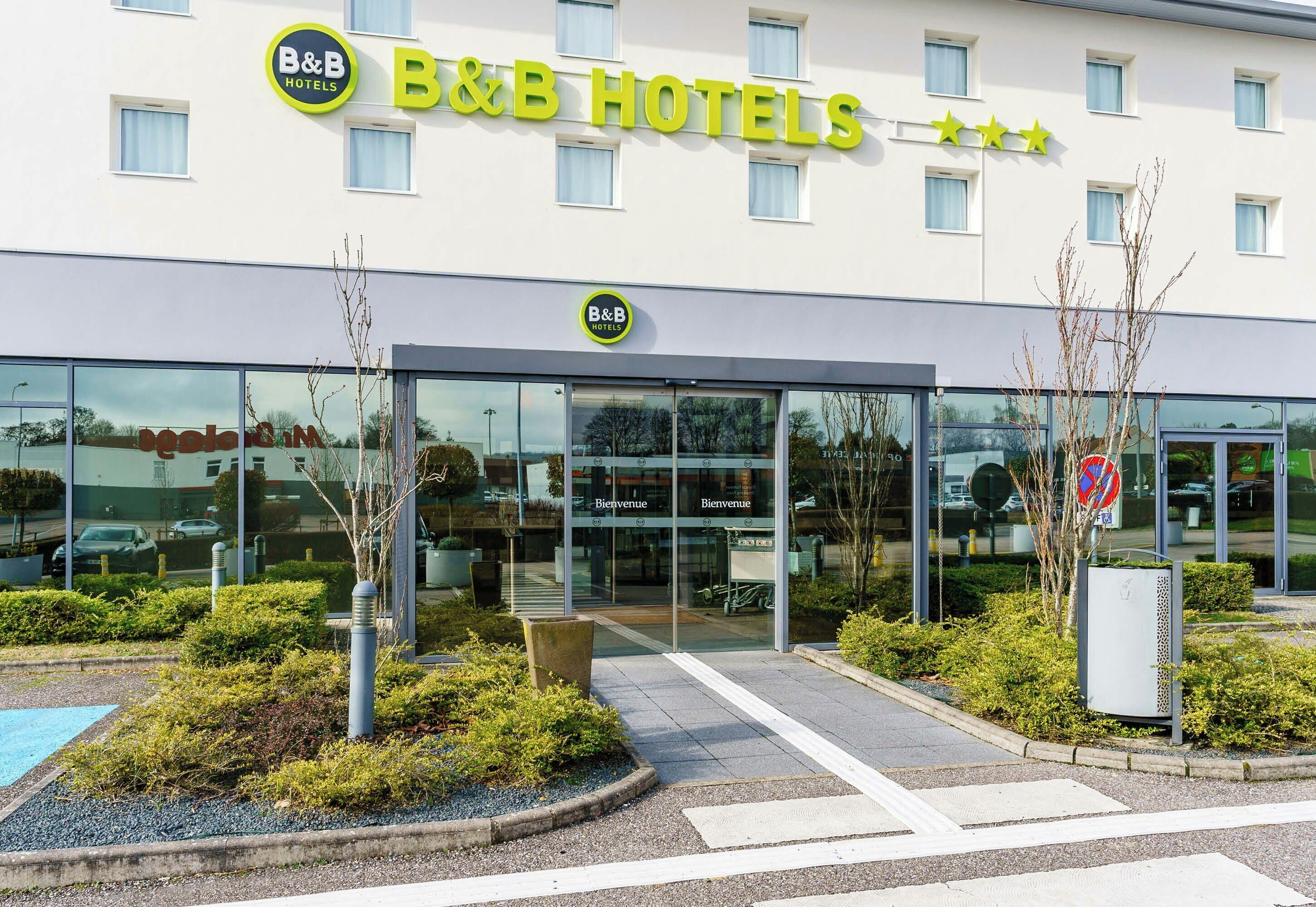 A B&B hotel with a modern facade, large windows, and a welcoming entrance.