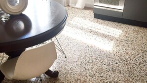 Un coin repas avec une table ronde, une chaise et une cuisine en arrière-plan.