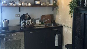 Une cuisine équipée d’un four encastré, d’un évier et d’un plan de travail sur lequel sont disposés divers ustensiles de cuisine.