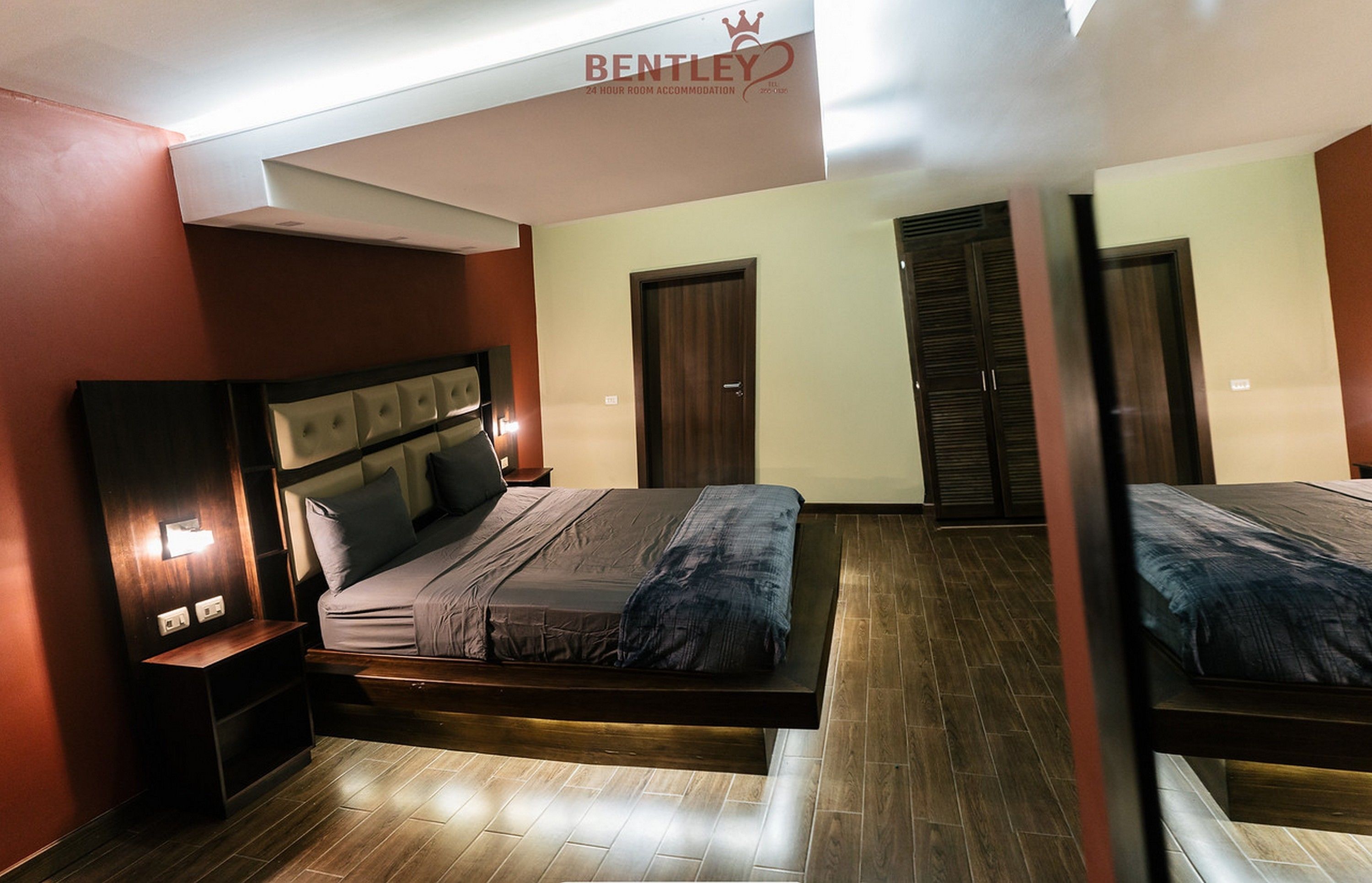Een moderne slaapkamer met een bed, nachtkastjes en een kledingkast.