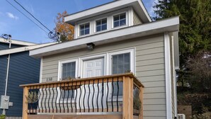 A two-story house with a balcony, a number '130' on the side, and a small porch area.