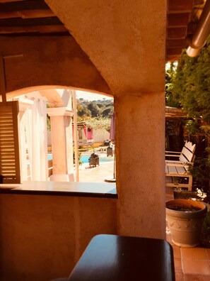 Blick aus dem Fenster auf einen Pool und Gartenmöbel.