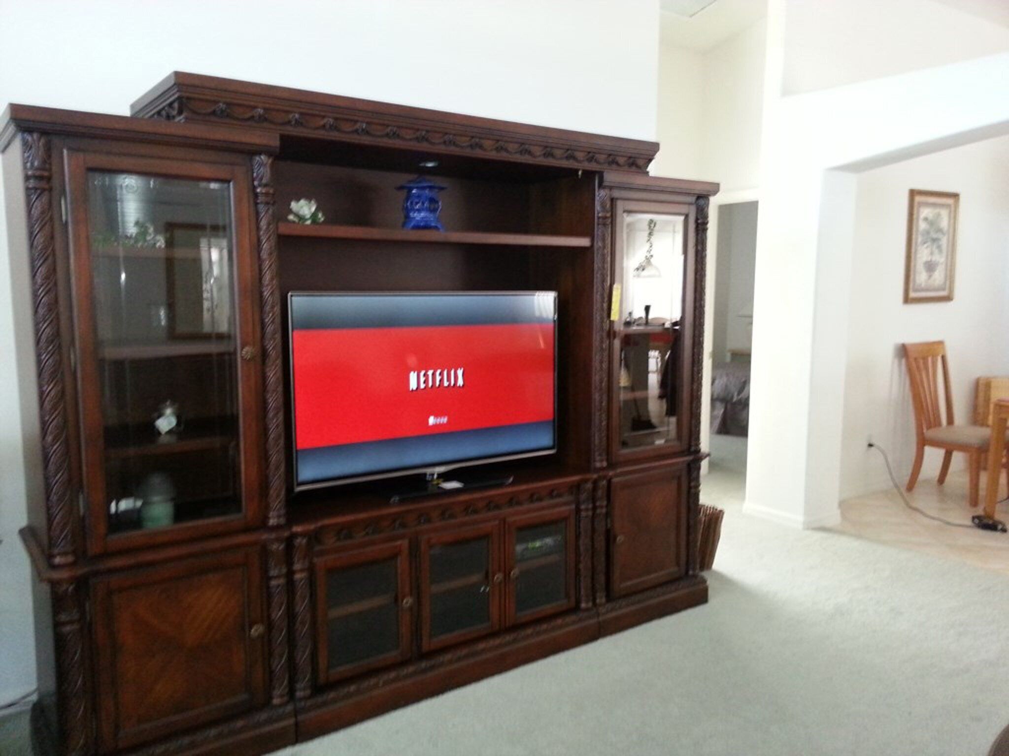 Eine Holz-Unterhaltungsecke mit einem Flachbildfernseher, der das Netflix-Logo zeigt.