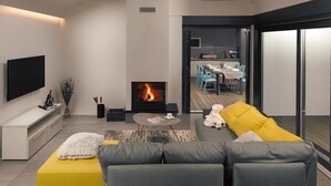 A modern living room with a flat-screen TV, a fireplace, a sofa, and a dining area visible through a glass door. - Beautiful Villa Linea near the sea with private pool! (Fazana)