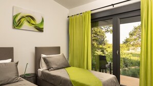 A bedroom with two beds, a green curtain, and a view of greenery outside. - Beautiful Villa Linea near the sea with private pool! (Fazana)
