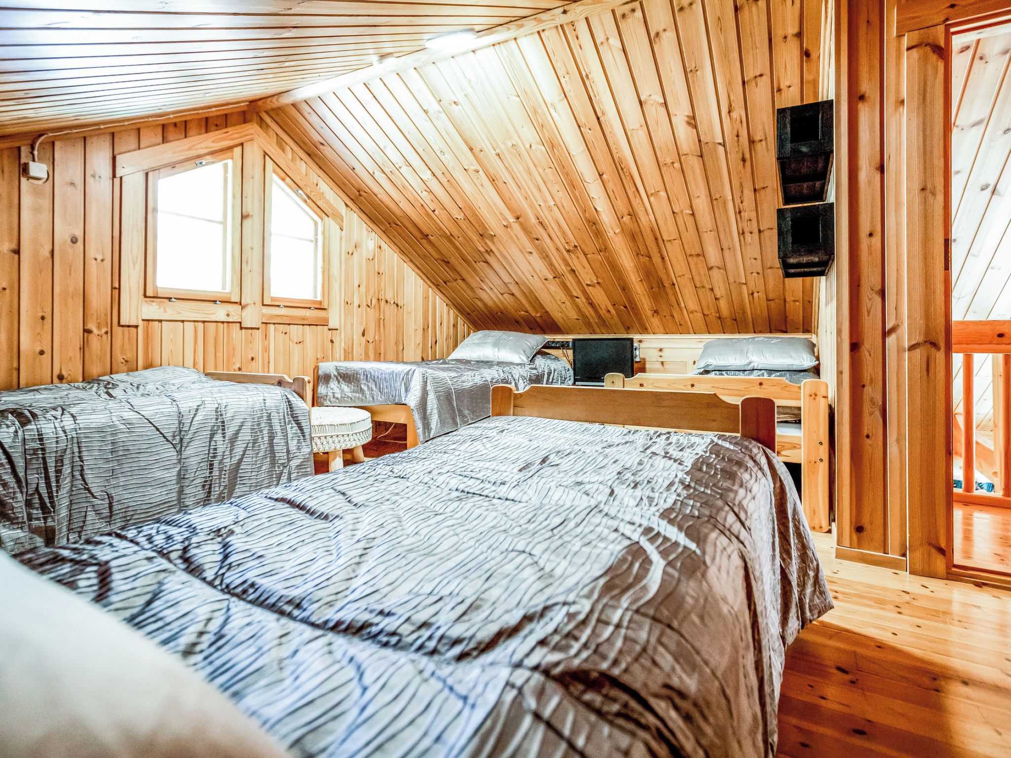 A cabin with two beds, a window, and a television.