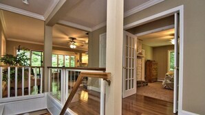Ein geräumiges Interieur mit einer Holztreppe, Blick ins Freie und einer gemütlichen Sitzecke.