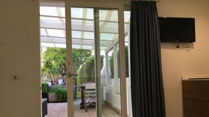 Ein Zimmer mit einer Schiebetür aus Glas, die auf eine Außenpatio führt.