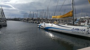 A marina with multiple sailboats docked, featuring a prominent boat named 'SAONA' with 'MAXI CA' and '64' visible on its side. - Sea view, beach and port 2m away on foot, private parking  (Agde)