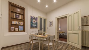 A compact living space with a dining area, a bookshelf, and a poster on the wall. - Tilia (Bologna)