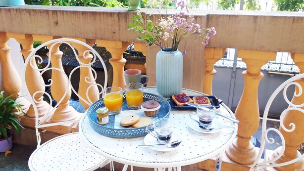 A table set with breakfast items including toast, muffins, and a glass of orange juice. - Tilia (Bologna)
