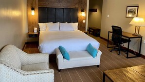 A hotel room with a large bed, a desk, a chair, and a ceiling fan. - Peaks Penthouse #643 (Mountain Village)