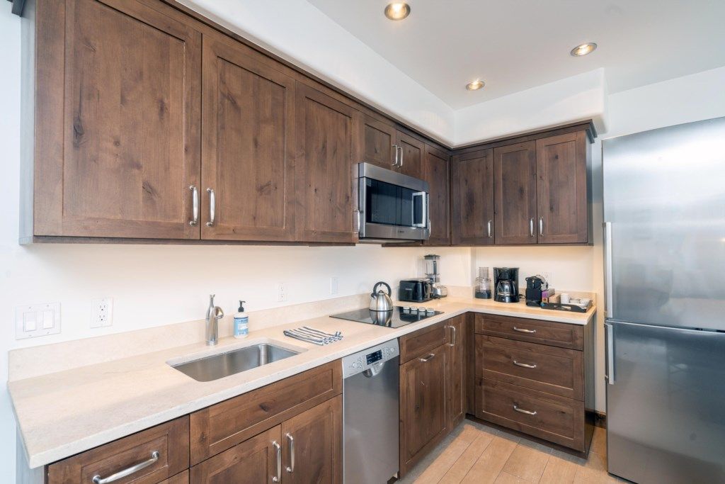 Una cocina con armarios de madera, electrodomésticos de acero inoxidable y lavavajillas.
